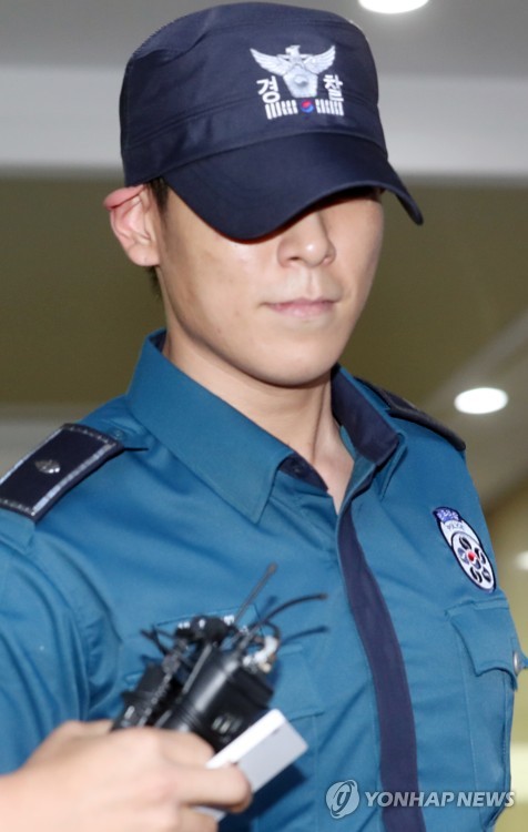 South Korean singer and actor T.O.P of boy band BIGBANG, who is serving his mandatory military service as a conscripted policeman, leaves his workplace in Seoul surrounded by reporters questioning his marijuana charges on June, 5, 2017. (Yonhap)