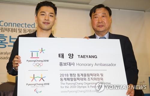 Taeyang (L), a member of boy group BIGBANG, poses with Lee Hee-beom, chairman of the organizing committee for the 2018 PyeongChang Winter Olympics, after receiving a letter of appointment as a promotional ambassador for the sports event at the Press Center in Seoul on June 21, 2017. (Yonhap) 